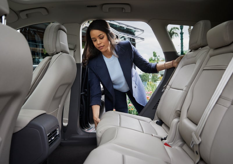 A woman slides the second-row seat forward to create more cargo space | Sentry Lincoln in Medford MA