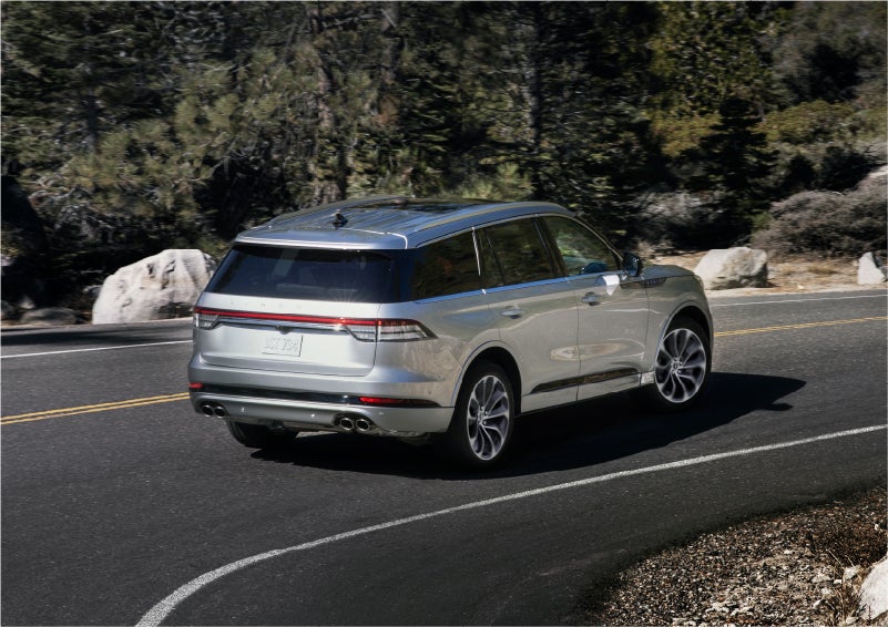 A 2023 Lincoln Aviator® Grand Touring model is shown being driven on a tight turn of a mountain road | Sentry Lincoln in Medford MA