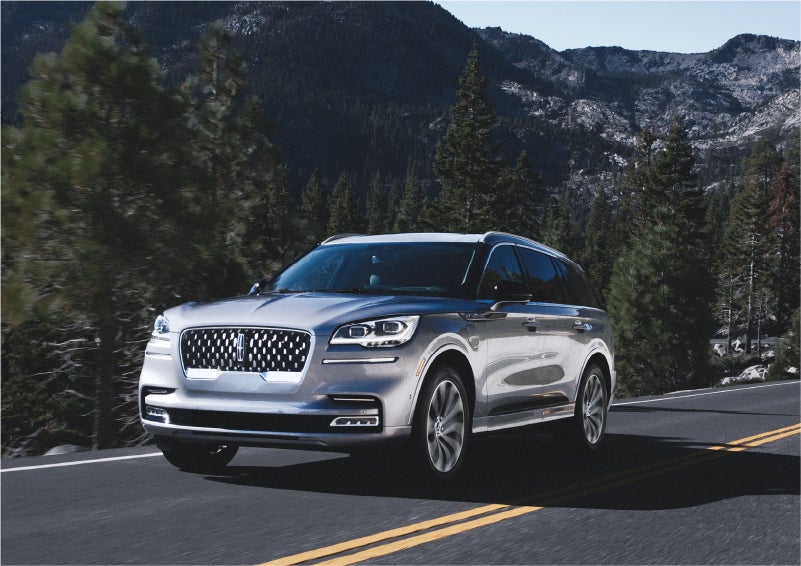 A 2023 Lincoln Aviator® Grand Touring SUV being driven on a winding road to demonstrate the capabilities of all-wheel drive | Sentry Lincoln in Medford MA