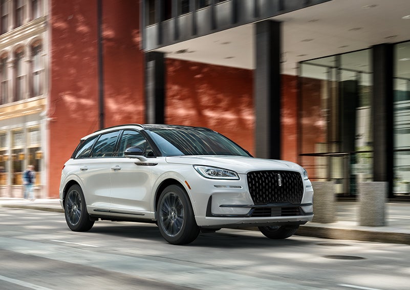 The 2024 Lincoln Corsair® SUV with the Jet Appearance Package and a Pristine White exterior is parked on a city street. | Sentry Lincoln in Medford MA