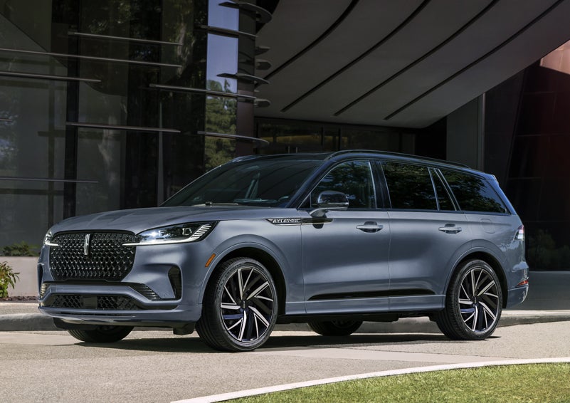 A gray 2025 Lincoln Aviator® SUV is parked outside a modern building showcasing the driver’s side of the vehicle. | Sentry Lincoln in Medford MA