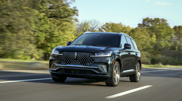 A 2025 Lincoln Black Label Aviator® SUV is being driven down a road lined with trees. | Sentry Lincoln in Medford MA
