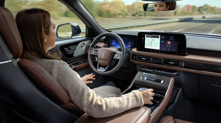 A woman is seen sitting in the driver’s seat of her 2025 Lincoln Aviator® SUV with her hands off the steering wheel. | Sentry Lincoln in Medford MA