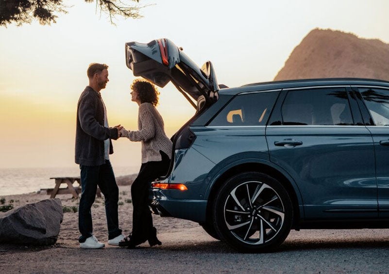A couple share a moment together outside a 2025 Lincoln Corsair® SUV near the open liftgate. | Sentry Lincoln in Medford MA