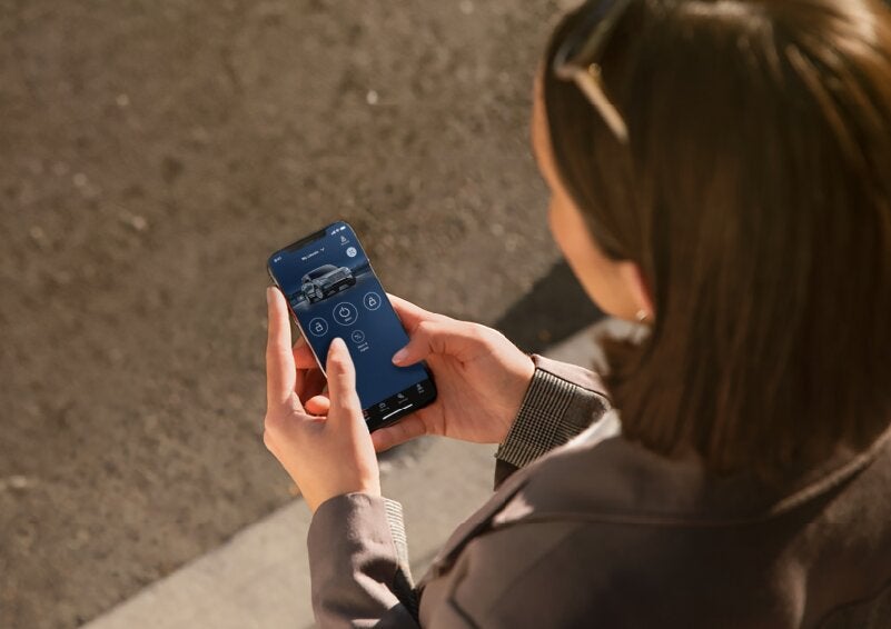 A person is shown interacting with a smartphone to connect to a Lincoln vehicle via the Lincoln Way® App. | Sentry Lincoln in Medford MA