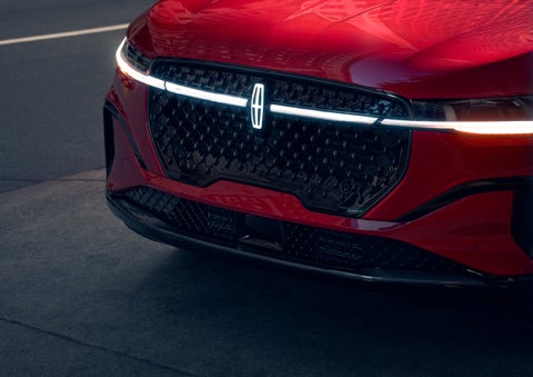 The available front LED light bar and center Lincoln Star logo glow at dusk. | Sentry Lincoln in Medford MA