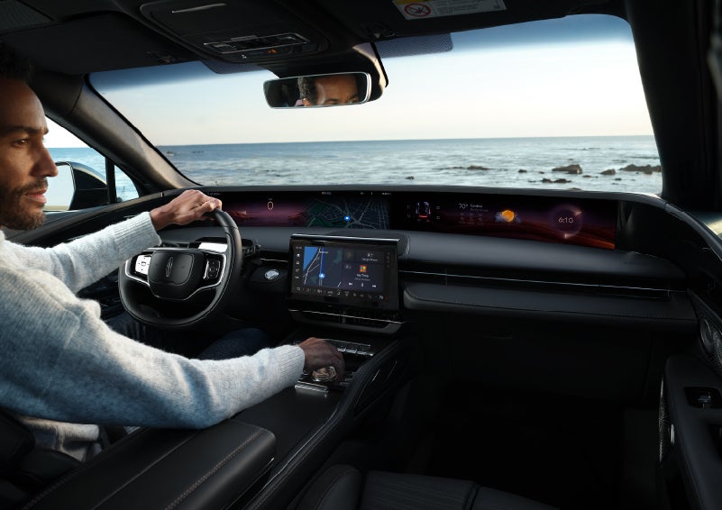 A driver of a parked 2025 Lincoln Nautilus® SUV takes a relaxing moment at a seaside overlook while inside his Nautilus. | Sentry Lincoln in Medford MA