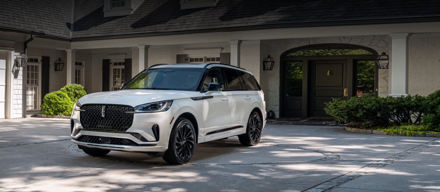 A 2026 Lincoln Aviator® SUV is parked in the driveway of an upscale home.